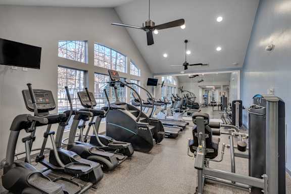 A gym with treadmills, elliptical machines, and other exercise equipment.