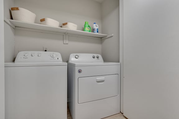 A white washing machine and dryer in a small laundry room.