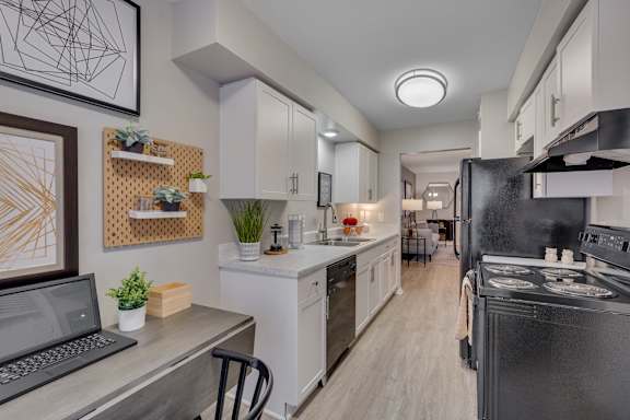 A modern kitchen with a laptop on the counter.