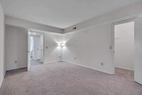 A large, empty room with carpeted floors and white walls.