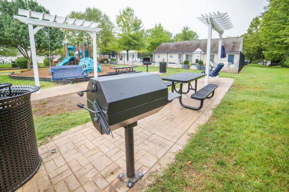 Outdoor gill and seating area. Playground in background.