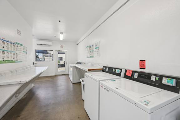 A laundromat with a row of washers and dryers.