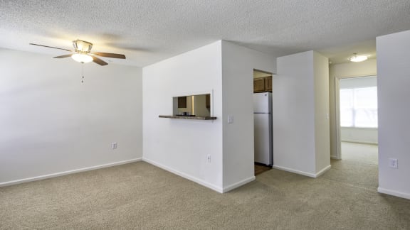 a bedroom with a ceiling fan and a refrigerator