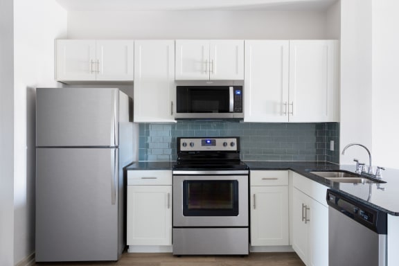 a kitchen with stainless steel appliances and white cabinets