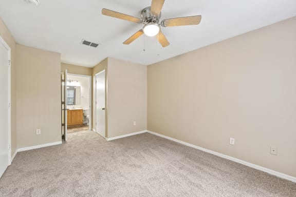 a bedroom with a ceiling fan and carpet