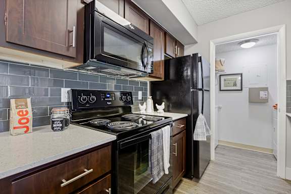 A kitchen with black appliances and brown cabinets