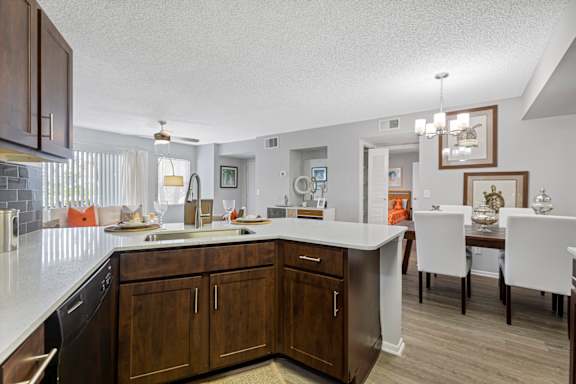 A kitchen with brown cabinets and a white counter.
