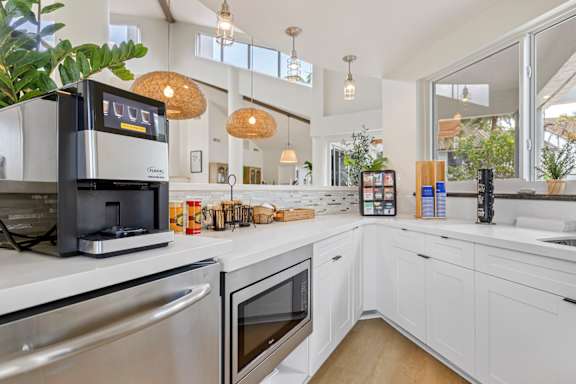 clubhouse kitchen with white cabinets and stainless steel appliances.