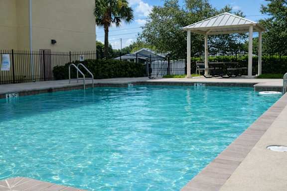 A pool with a gazebo in the background.