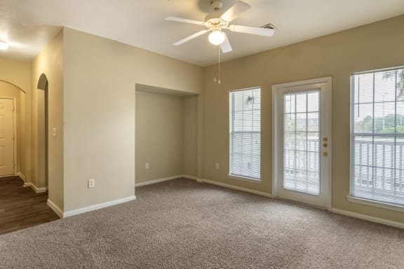 a bedroom with three windows and a ceiling fan