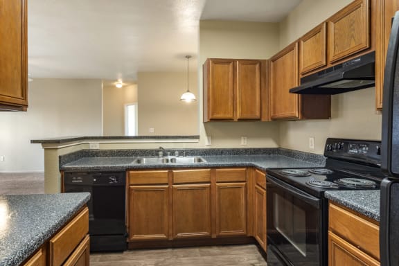 a kitchen with black appliances and wood cabinets