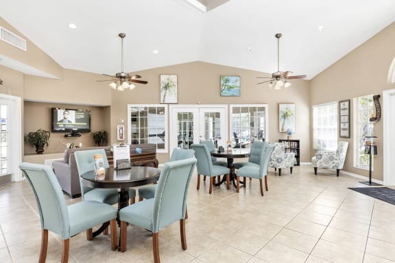 Interior of clubhouse facing a common area with chairs and tables