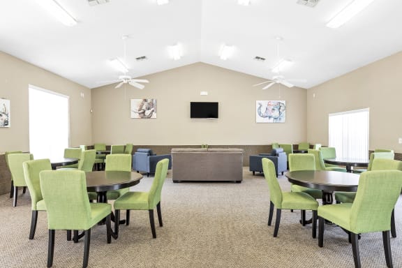Interior of resident community room with tables and a couch