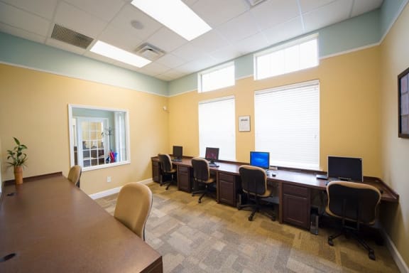 Clubhouse business center equipped with computers and conference table