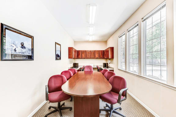 Business Center with Conference Table Maroon Chairs and Computers and Wood Cabinets