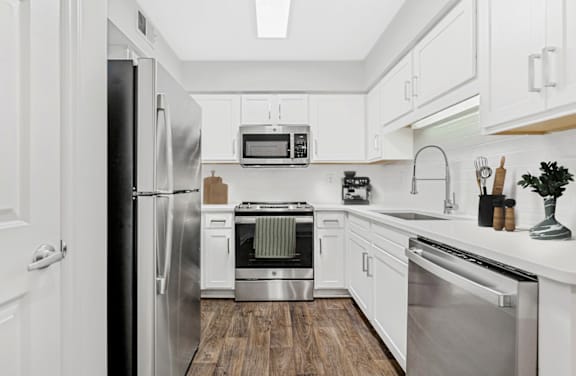 a kitchen with white cabinetry and stainless steel appliances at Caveness Farms Apartments, Wake Forest, 27587
