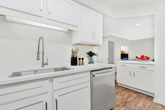 a kitchen with white cabinets and a stainless steel dishwasher at Caveness Farms Apartments, Wake Forest, NC 27587