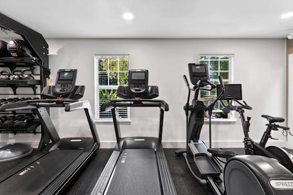 a gym with treadmills and exercise bikes at Caveness Farms Apartments, Wake Forest, NC