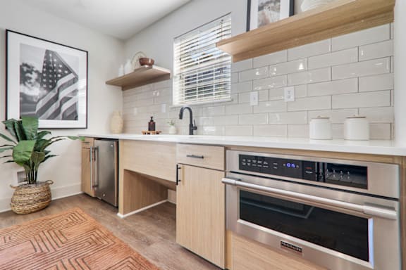 a kitchen with wooden cabinets and white countertops at Caveness Farms Apartments, North Carolina, 27587