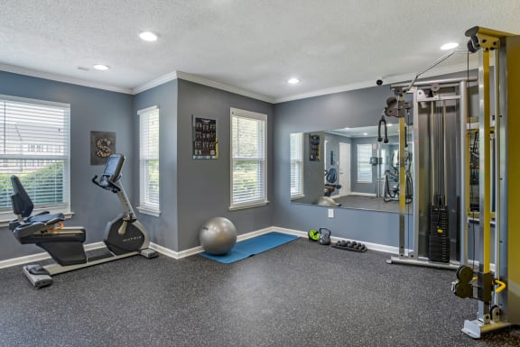 Fitness Center with Exercise Equipment and Mirror Accent Wall