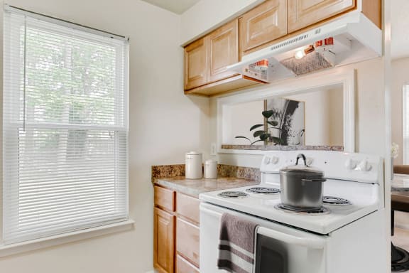 a kitchen with a stove top oven next to a window