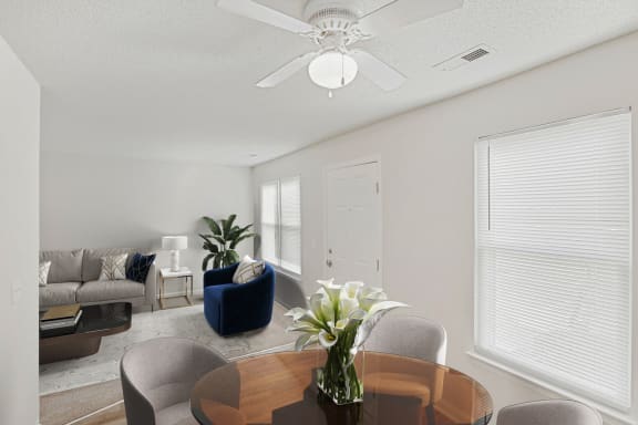 a living room and dining room with white walls and a white ceiling fan