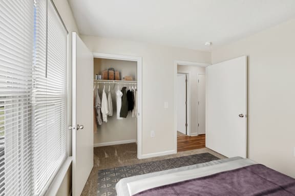 a bedroom with a large window and a closet