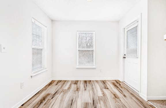 dining room with wood flooring, windows and door leading  to exterior.