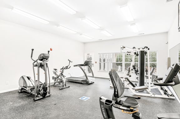 Bright Fitness Center with Exercise Equipment and Mirrored Wall and large window