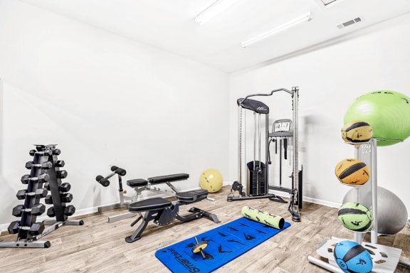 Bright Fitness Center with Exercise Equipment , free weights, and yoga mat.