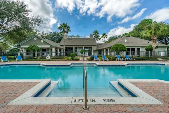 Swimming pool lounge seating, sun deck, with clubhouse in the background