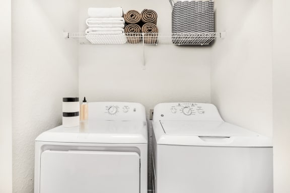 Virtually staged laundry area with shelf, towels, and basket
