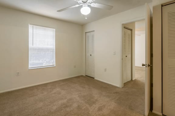 Bedroom with carpet flooring, multi speed ceiling fan, and window for natural lighting