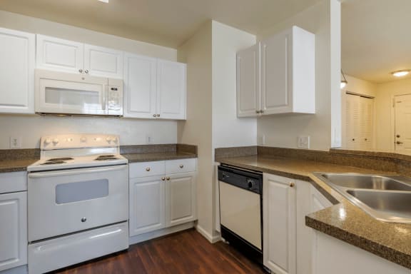 Kitchen with white appliances and hardwood style flooring