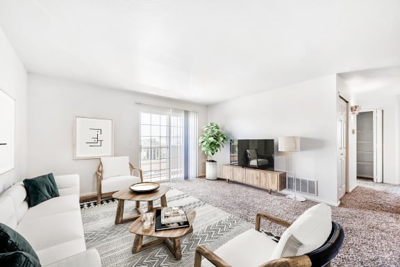 Modell Apartment with Couch, Armchairs, Coffee Tables, Entertainment Center and TV Next to Sliding Glass Patio Door