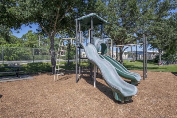 Green Playground on Mulch with Nearby Picnic Table