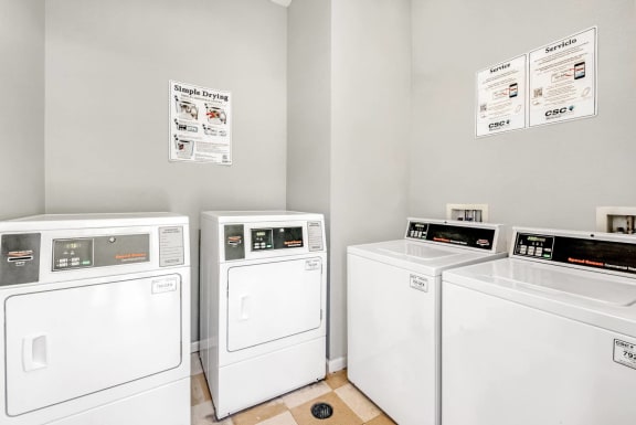 Laundry center with white washers and dryers.