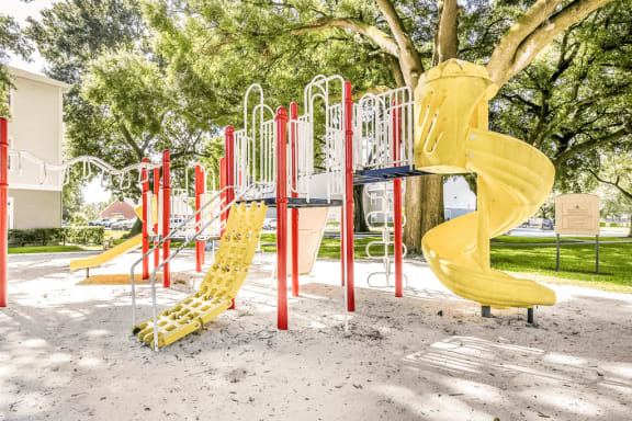 Playground with multiple slides, monkey bars and surrounding native landscape