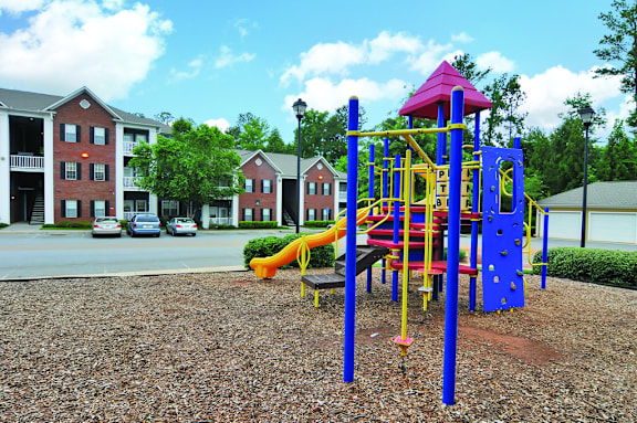 A playground with a blue and yellow slide and a red and yellow tower.