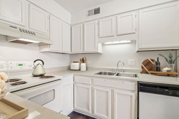 a kitchen with white cabinets and white appliances at Eastchester Ridge Apartments, High Point
