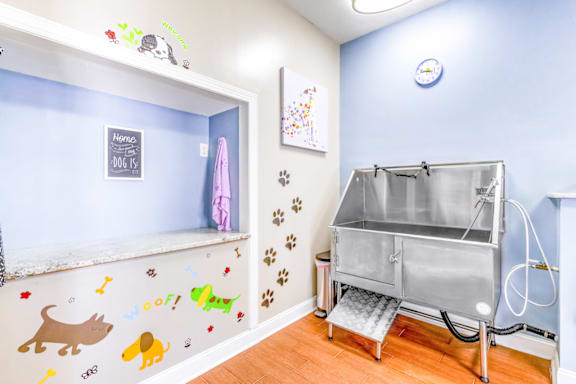 a laundry room with a tub in the corner and a shelf on the wall