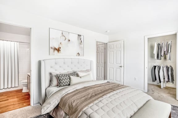 a bedroom with white walls and a white bed with a white tufted headboard