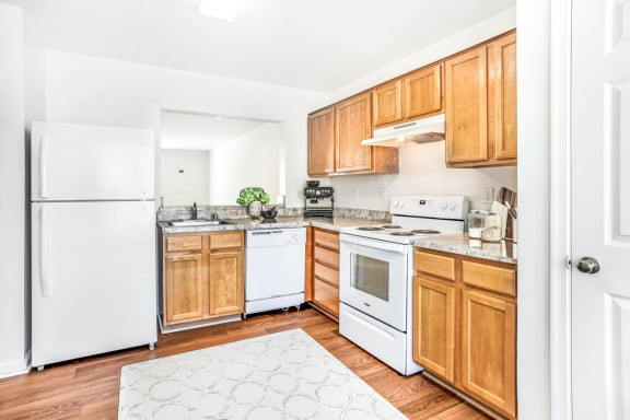 a kitchen with white appliances and wooden cabinets