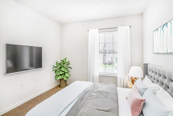 a bedroom with a large bed and a tv on the wall