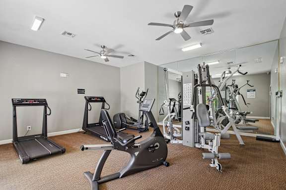 A spacious gym with treadmills, elliptical machines, and weight machines.