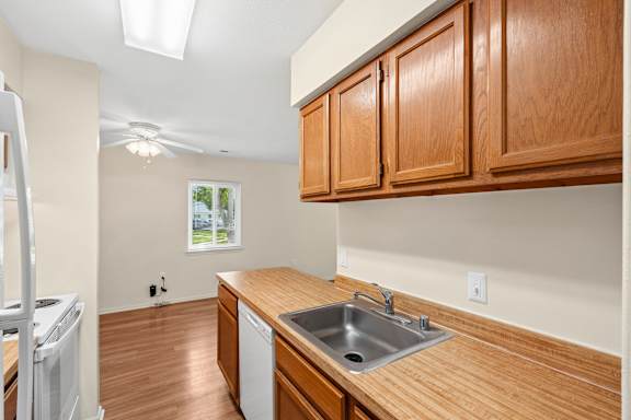 A kitchen with wooden cabinets and a stainless steel sink.