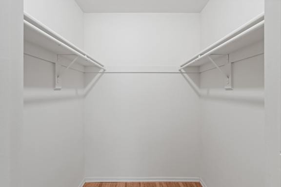 A white closet with a wooden floor.