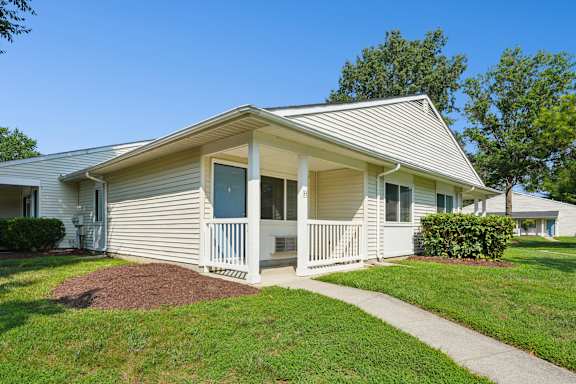A small house with a porch and a small front yard.