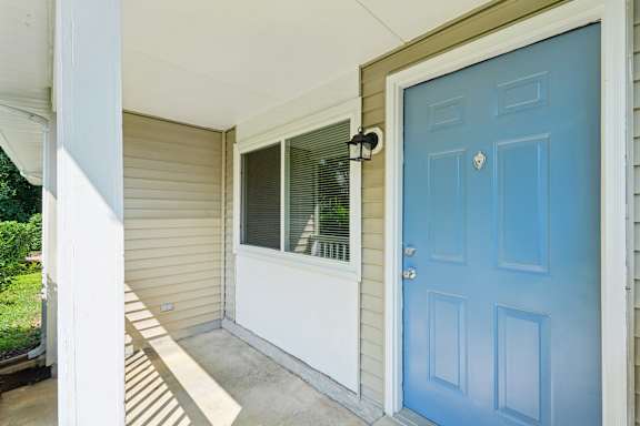 A blue door is on the right side of a house.
