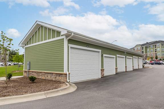 A green building with a white garage door at Foxwood Apartments, North Carolina, 27616
